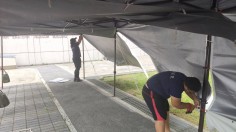 鴻揚展覽專業團隊於施工現場細心固定帳篷圍網，確保活動空間不受風雨干擾，提升活動質感